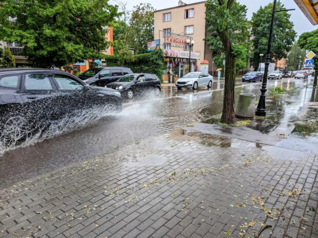 Samochód przejeżdżający ulicą zalaną po oberwaniu chmury